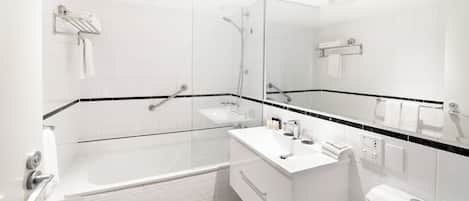 A modern bathroom with a glass-enclosed shower, a white sink, and a toilet.