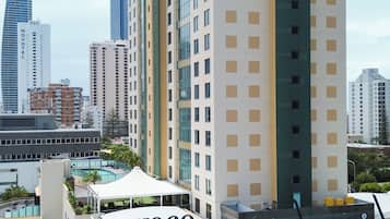 Un edificio de gran altura con un llamativo letrero 'YOCO', rodeado de otros edificios altos, lo que indica una zona urbana densa.