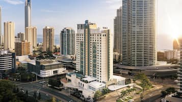 A cityscape with modern high-rise buildings, including a prominent building with 'YOCO' signage.