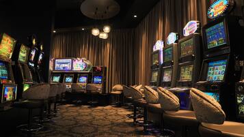 Experience the excitement of gaming in a well-lit space with easy access to slot machines and comfortable bar seating.