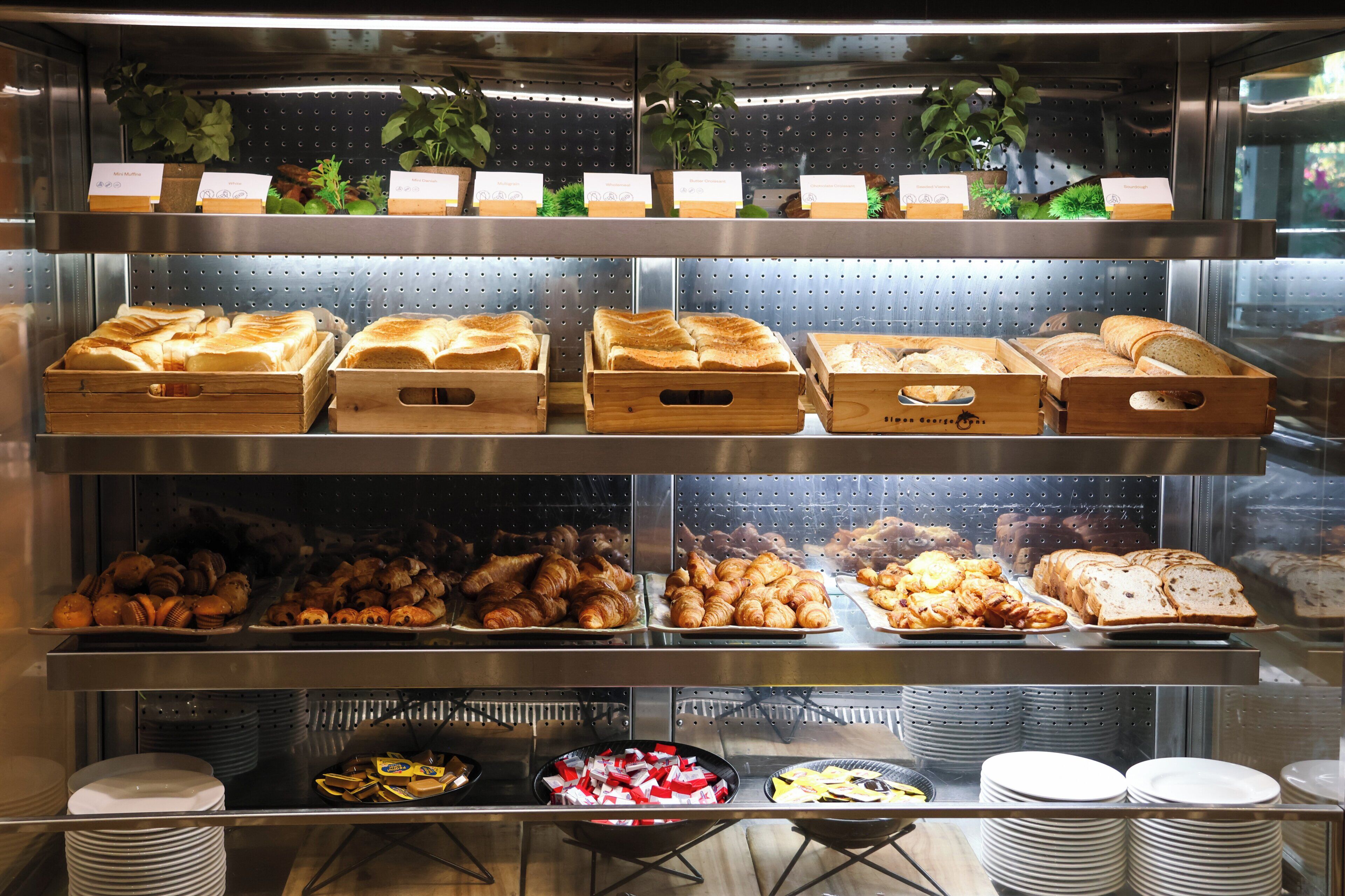 A bakery display with various baked goods and a selection of plates and bowls.