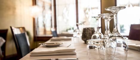 A dining table set with plates, cutlery, and clear glassware.