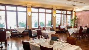 A restaurant with multiple tables set for dining, large windows with views, and a wooden floor. - Best Western Plus All Settlers Motor Inn (South Tamworth)