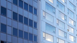 Un edificio moderno con una cuadrícula de ventanas y una estructura de esquina destacada.