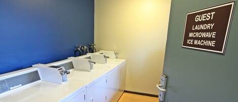 A guest bathroom with a blue wall, a white sink, and a sign indicating the availability of a guest laundry, microwave, and ice machine.