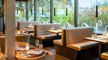 Enjoy a meal in our restaurant with comfortable seating areas and views of the outdoor greenery.