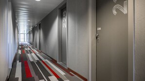 Un pasillo con puertas numeradas 222 y 226, un suelo con alfombra estampada e iluminación empotrada en el techo.