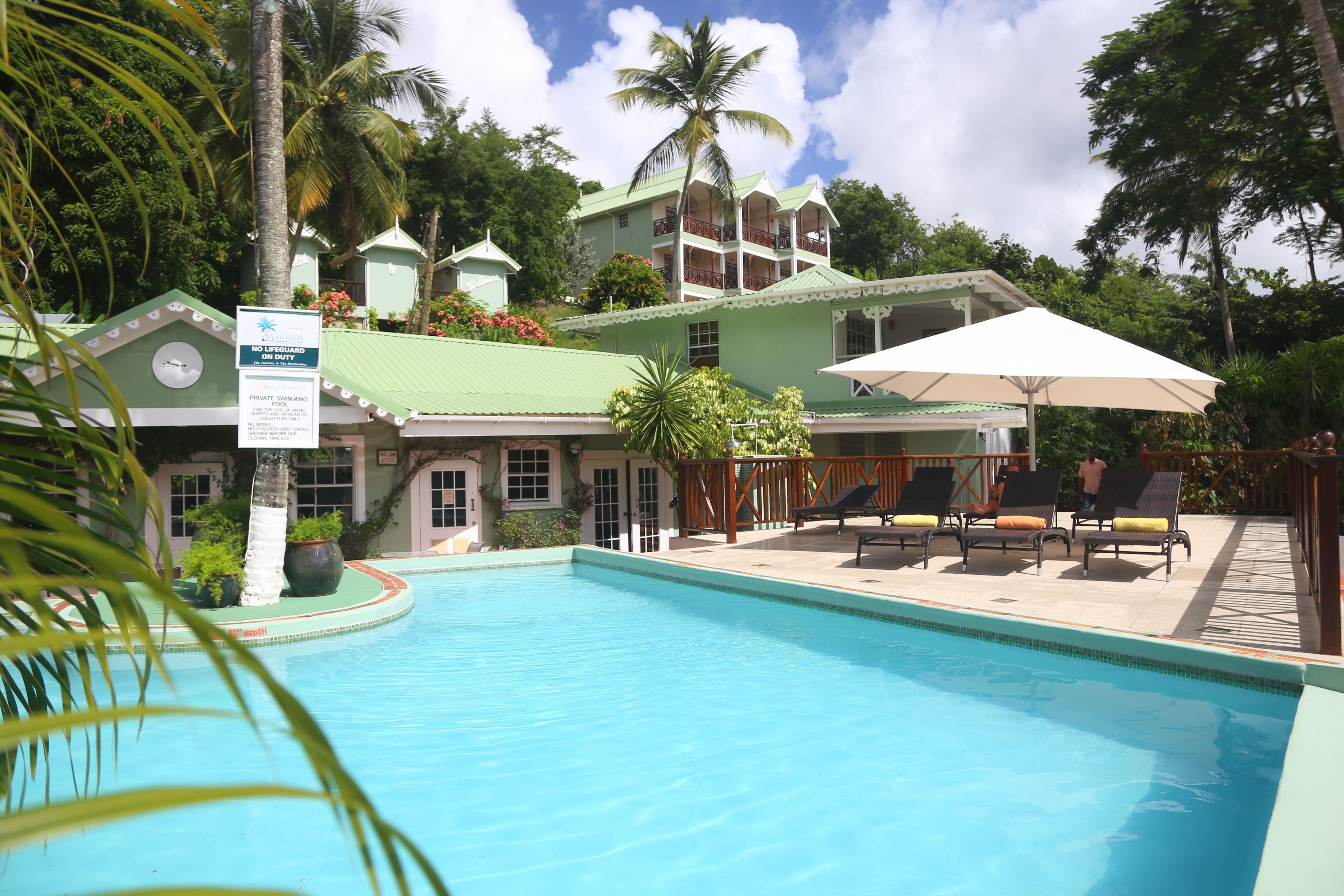 Uma área de piscina com espreguiçadeiras e um aviso indicando natação privativa.