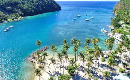 On the beach, sun loungers, beach umbrellas, beach towels. Marigot Beach Club and Dive Resort