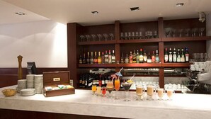 A bar area with shelves of liquor bottles, glasses, and a variety of beverages. - Bristol (Buenos Aires)