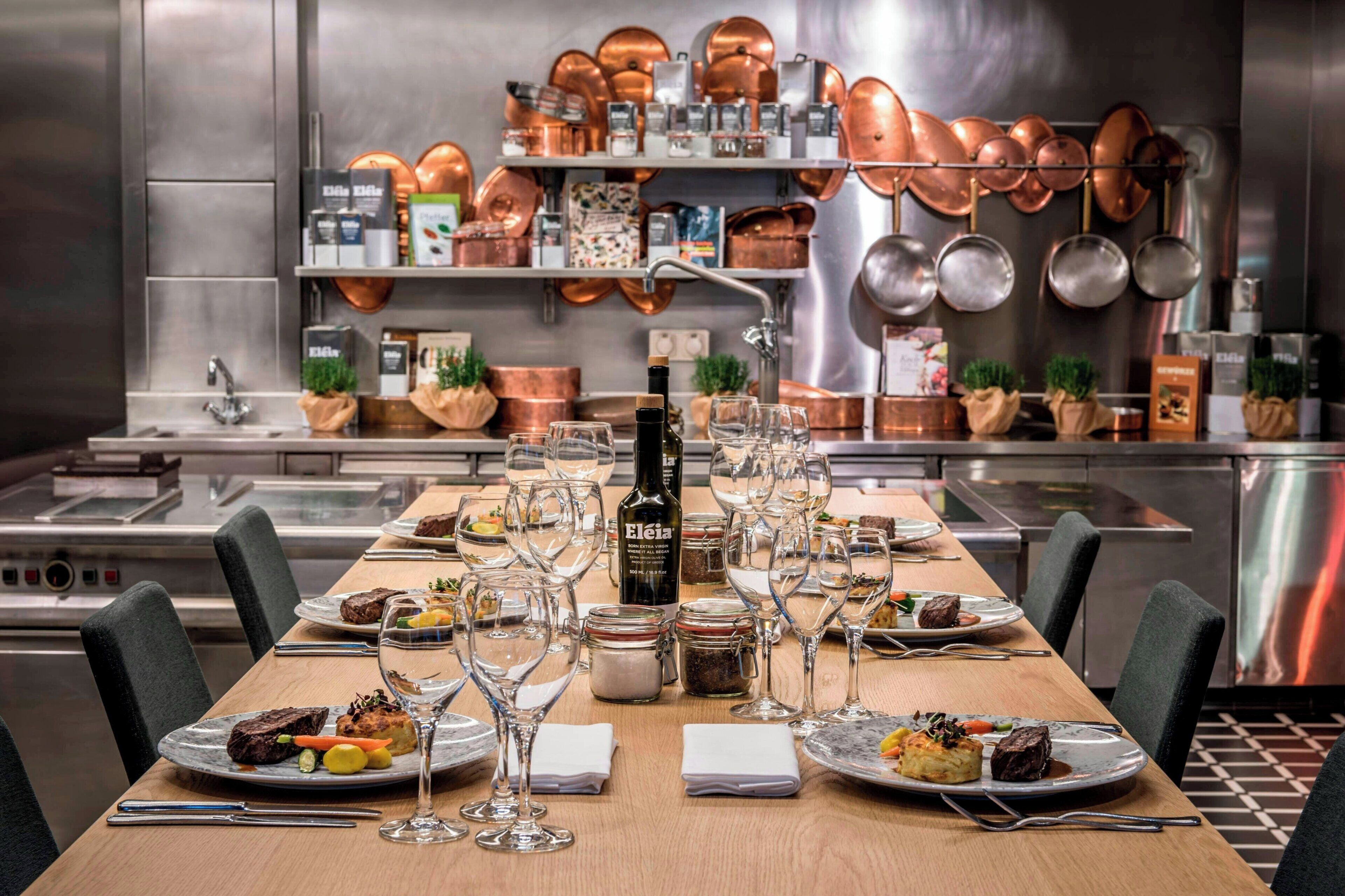 A restaurant setting with a long dining table, multiple wine glasses, and a bottle of wine.