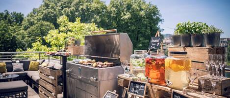 An outdoor bar area with a grill, beverage dispensers, and seating.