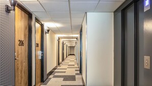A hotel hallway with doors numbered 206 and 208, a checkered carpet, and a ceiling with recessed lighting. - ibis Paris Gennevilliers (Gennevilliers)