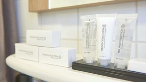 A display of spa collection products including a shower cap and body lotion on a countertop. - Huxley House Hotel (Amsterdam)