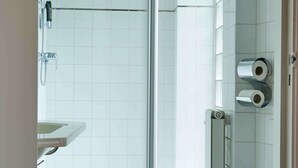 A modern bathroom with a shower, toilet, and sink. - Huxley House Hotel (Amsterdam)