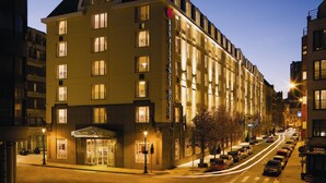 A multi-story hotel with a prominent entrance, large windows, and a well-lit facade.