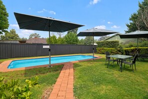 Una piscina al aire libre, tumbonas