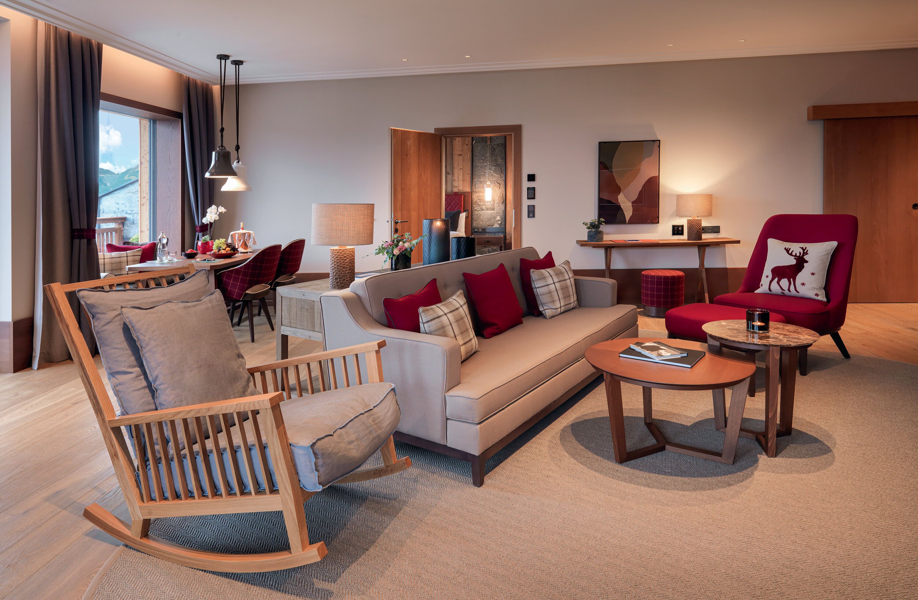 A modern living room with a sofa, chairs, a coffee table, and a dining area with a table and chairs.