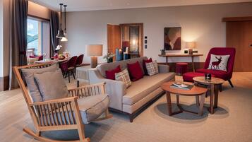 A modern living room with a sofa, chairs, a coffee table, and a dining area with a table and chairs.