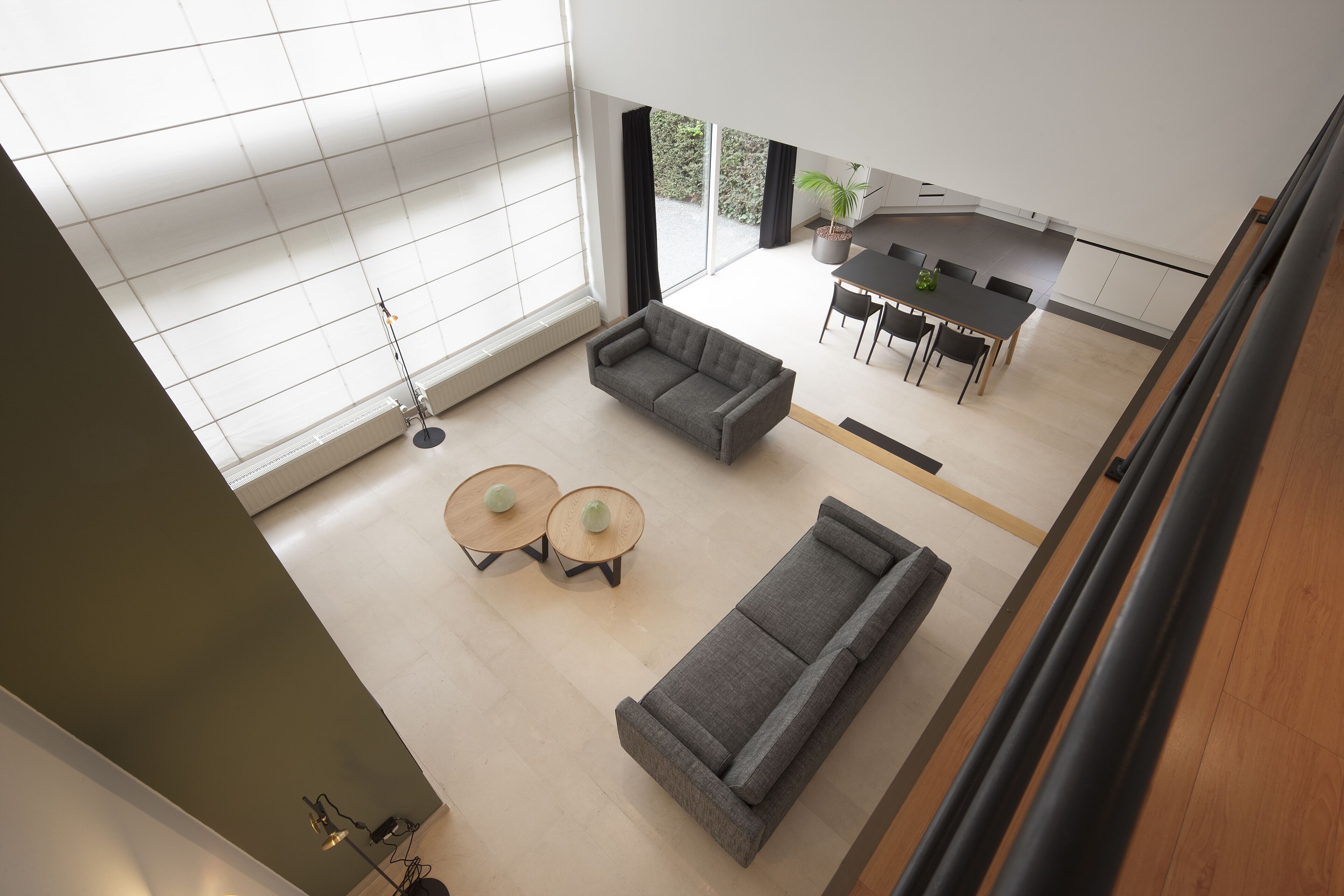 A spacious living area with a sofa, two round tables, and a dining table with chairs.