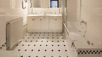 A modern bathroom with a large bathtub, a separate shower area, and a toilet.