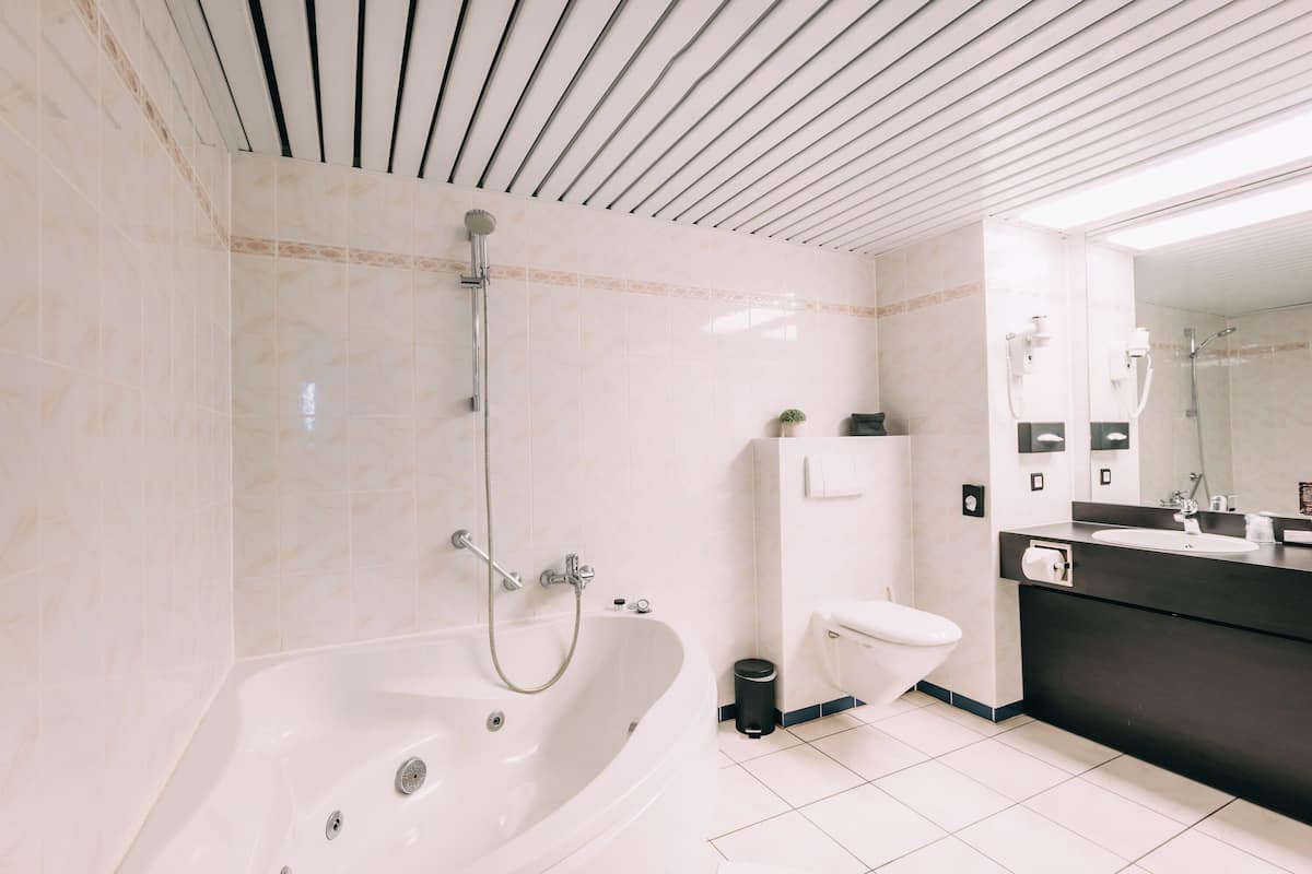 executive double room | bathroom | combined shower/bathtub, jetted bath, free toiletries, hair dryer