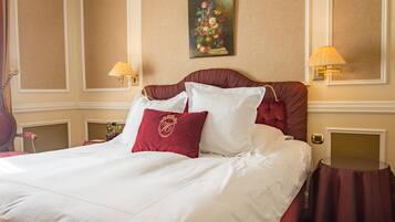 Een hotelkamer met een groot bed, twee bedlampen, een schilderij aan de muur en een kleine tafel.