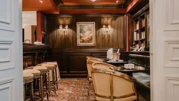 Une salle à manger élégante, avec des chaises à haut dossier, une longue table et un lustre.