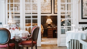 A dining area with tables set for a meal, chairs, and a chandelier. - Relais & Chateaux Hotel Heritage (Bruges)
