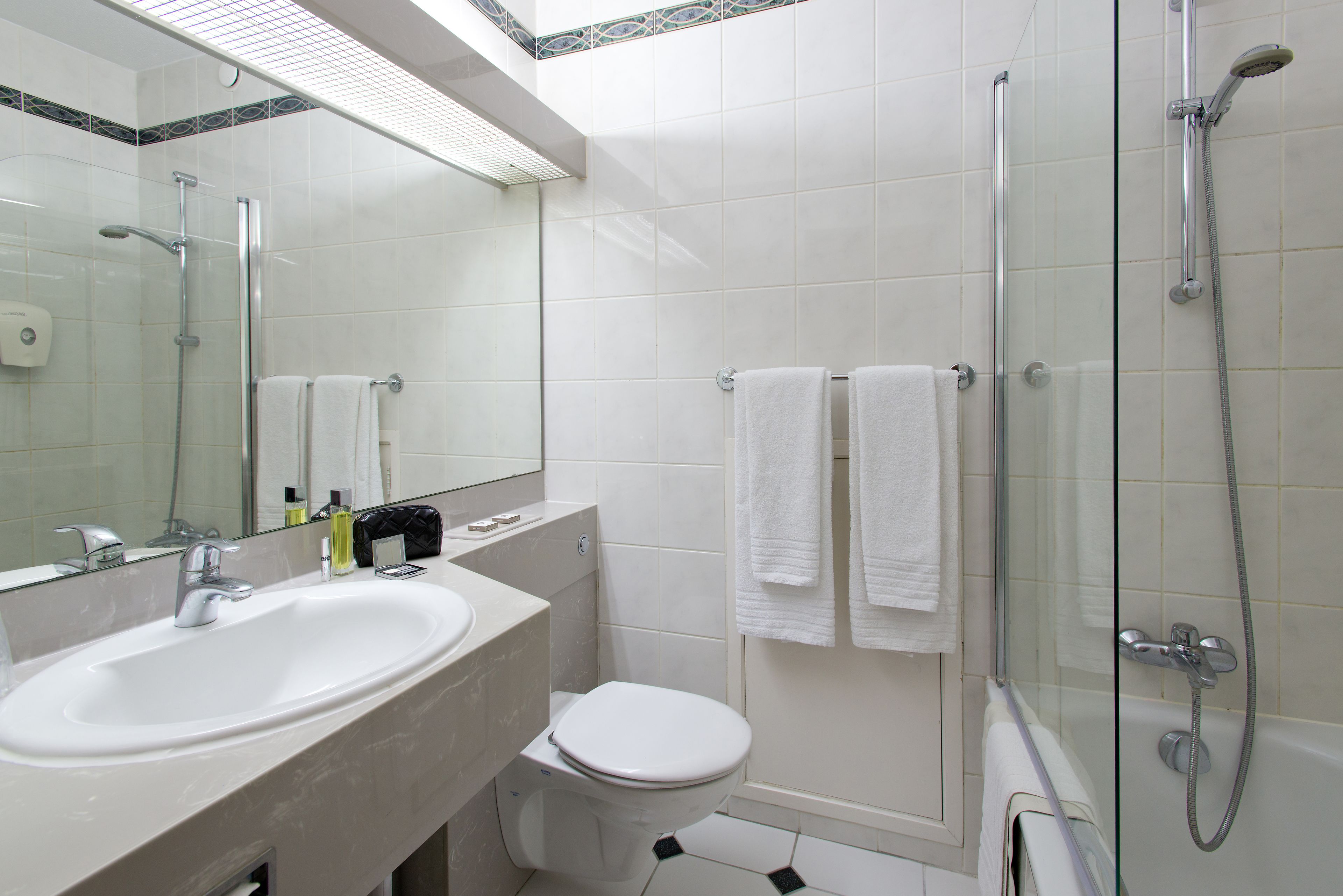 A modern bathroom with a glass-enclosed shower, a white sink, and a toilet.