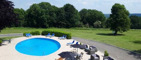 A swimming pool with lounge chairs and outdoor seating.