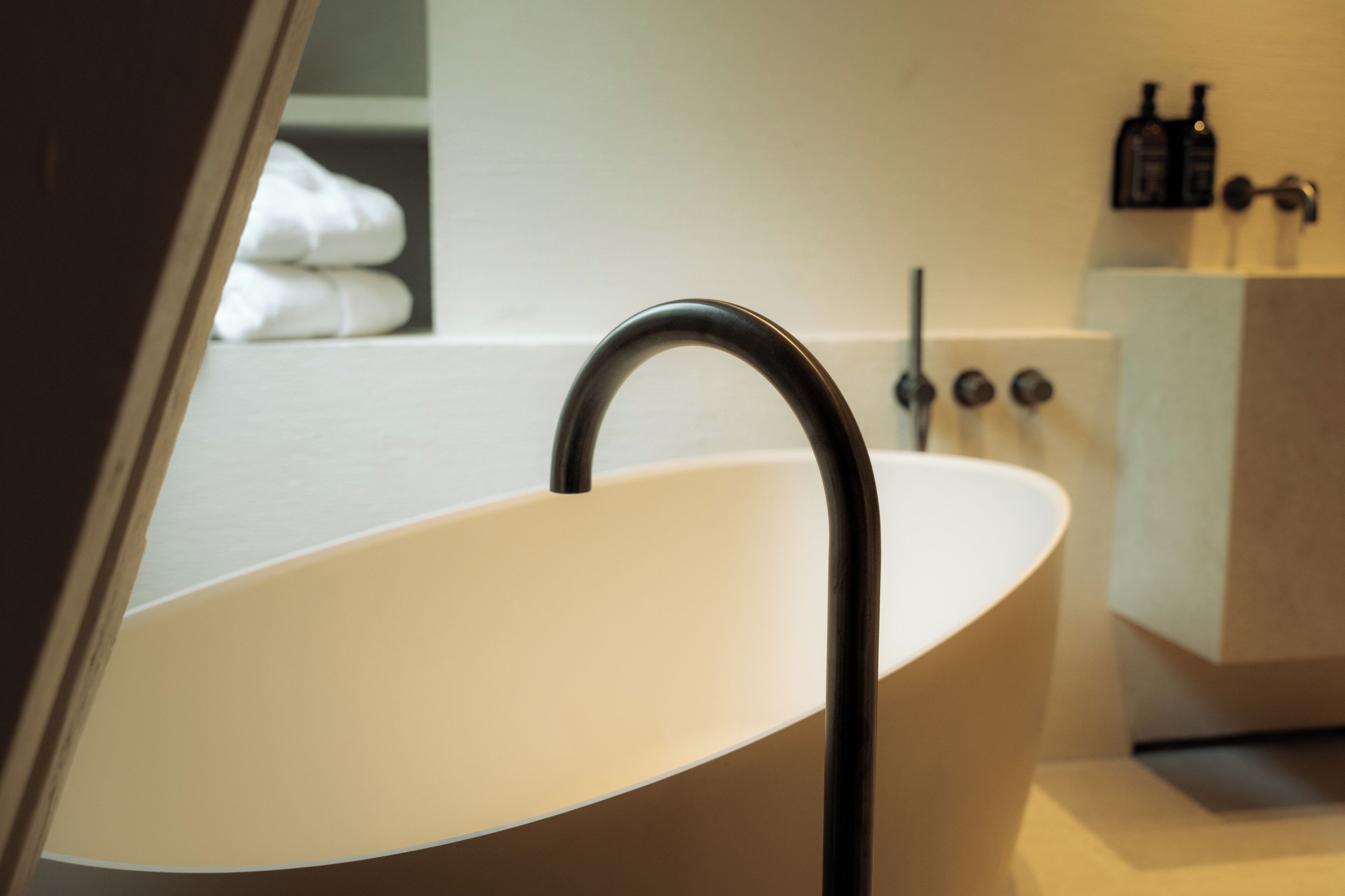 A modern bathroom with a freestanding bathtub, a visible towel rack, and a sink with a faucet.