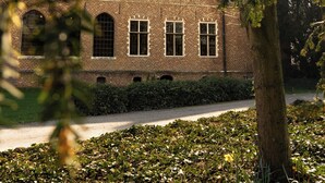 Un edificio de ladrillo con varias ventanas y un camino que lleva a él.
