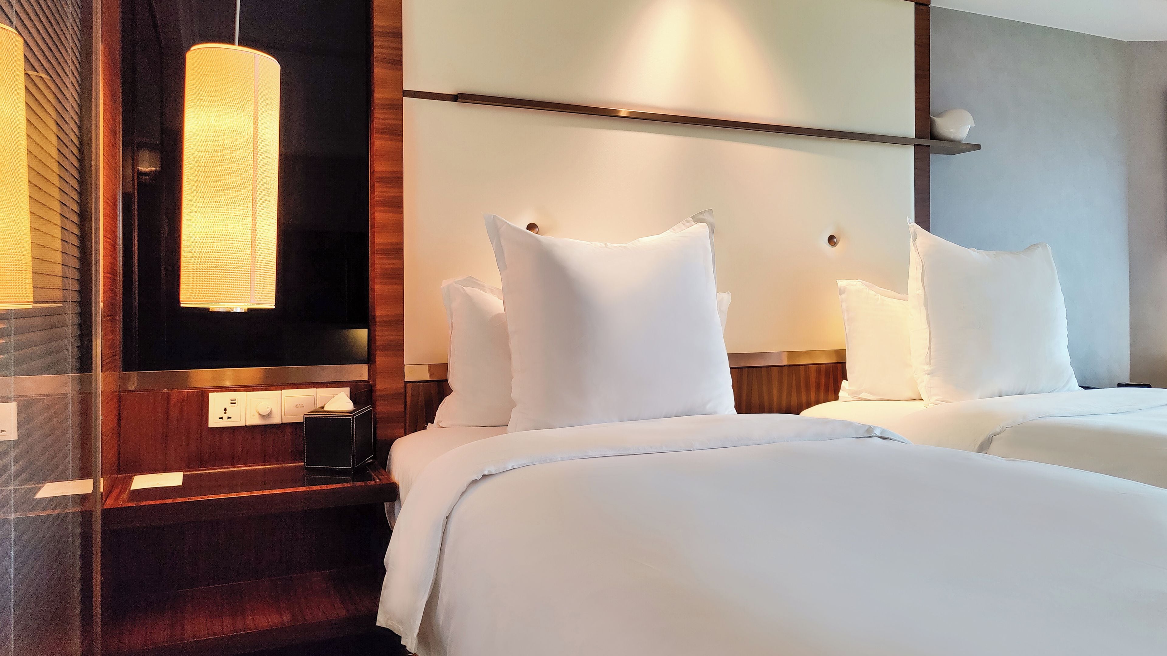 Ein Hotelzimmer mit Bett, Nachttischen, einem Spiegel und einer Wandleuchte.