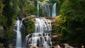 A multi-tiered waterfall surrounded by lush greenery.