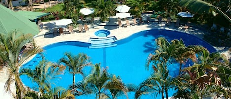 Una piscina al aire libre, sombrillas, sillones reclinables de piscina