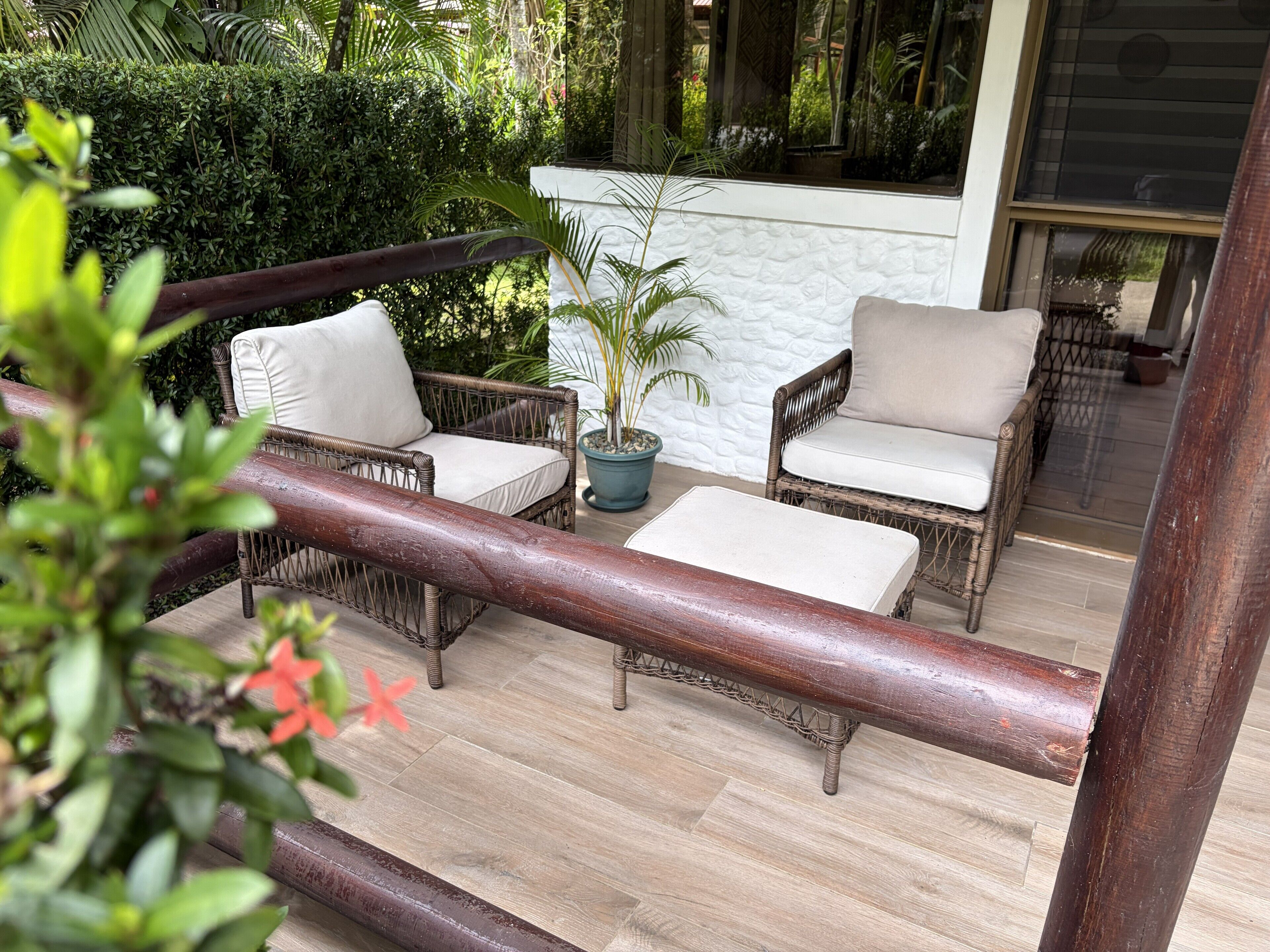 Eine Terrassenfläche mit Korbmöbeln und einem Blumentopf.