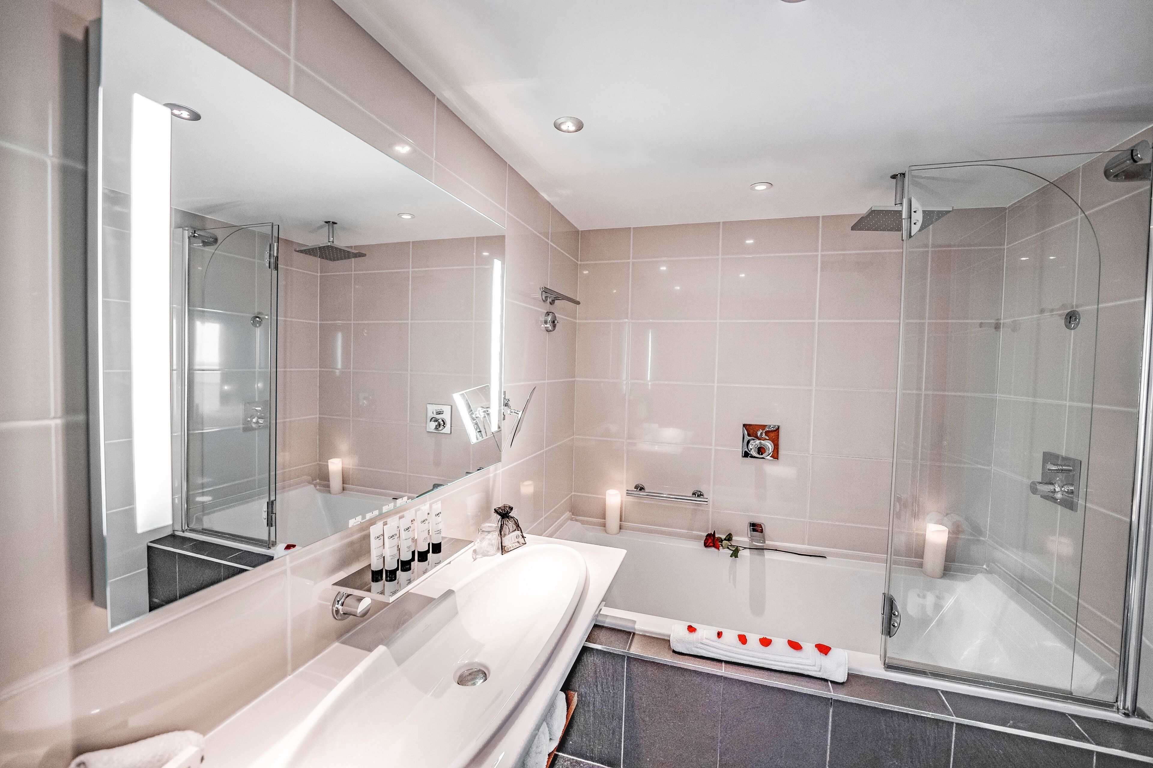 Ein modernes Badezimmer mit einem großen Spiegel, einer Badewanne und einer Duschkabine.
