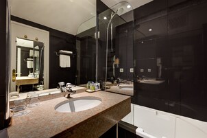 Un baño moderno con dos lavamanos, un espejo grande y una ducha con cerramiento de vidrio.
