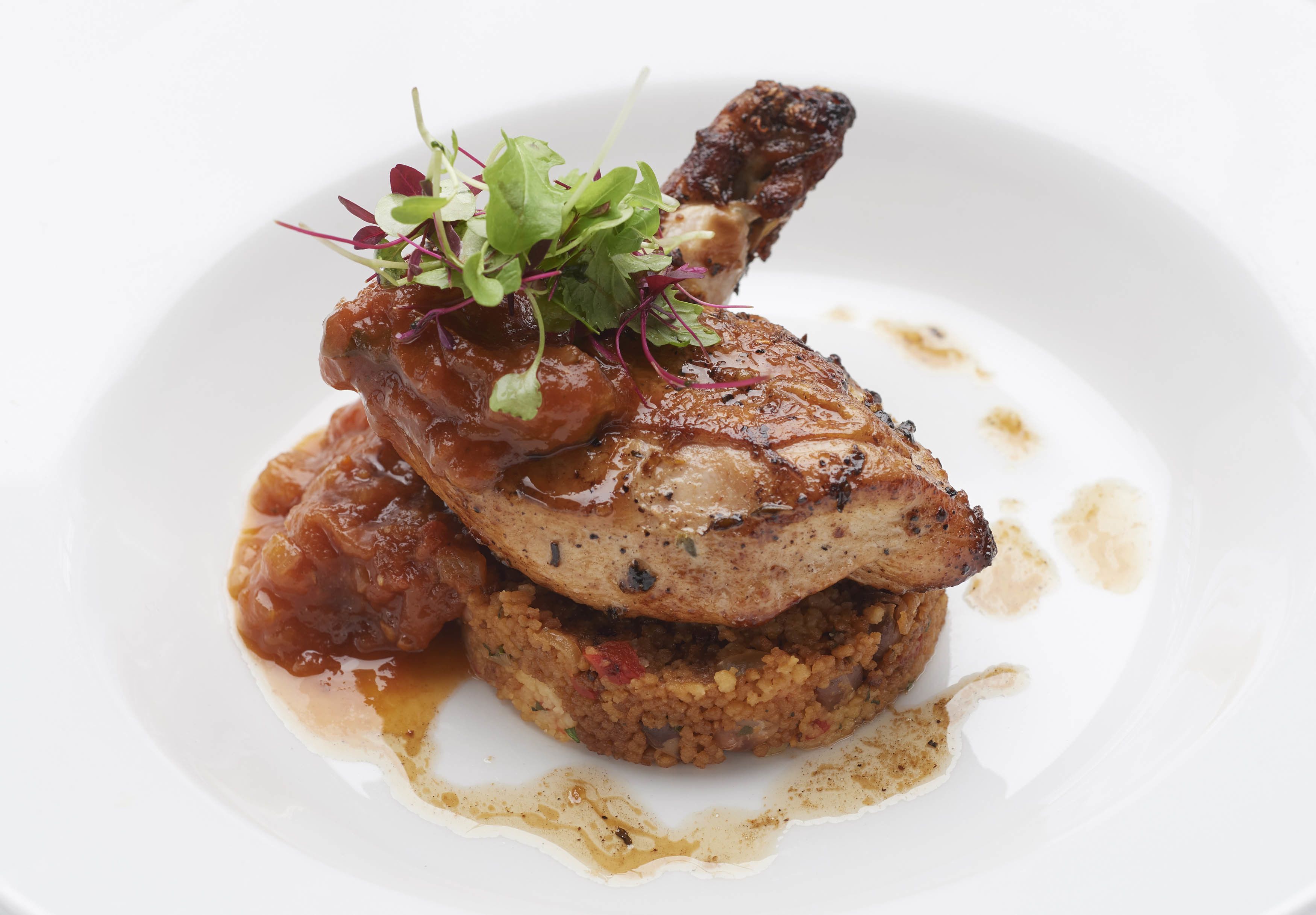 Un plato con carne, salsa y vegetales verdes.
