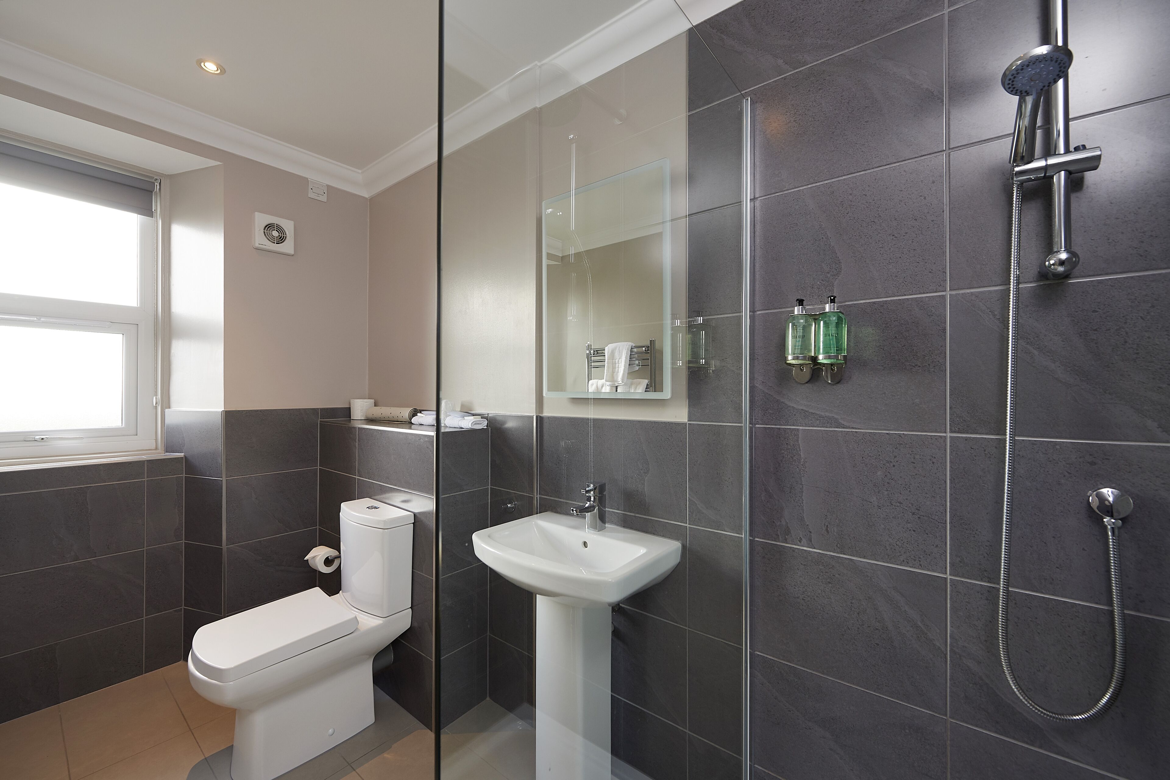 Ein modernes Badezimmer mit Toilette, Waschbecken und Dusche.