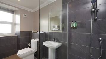 A modern bathroom with a toilet, sink, and shower.