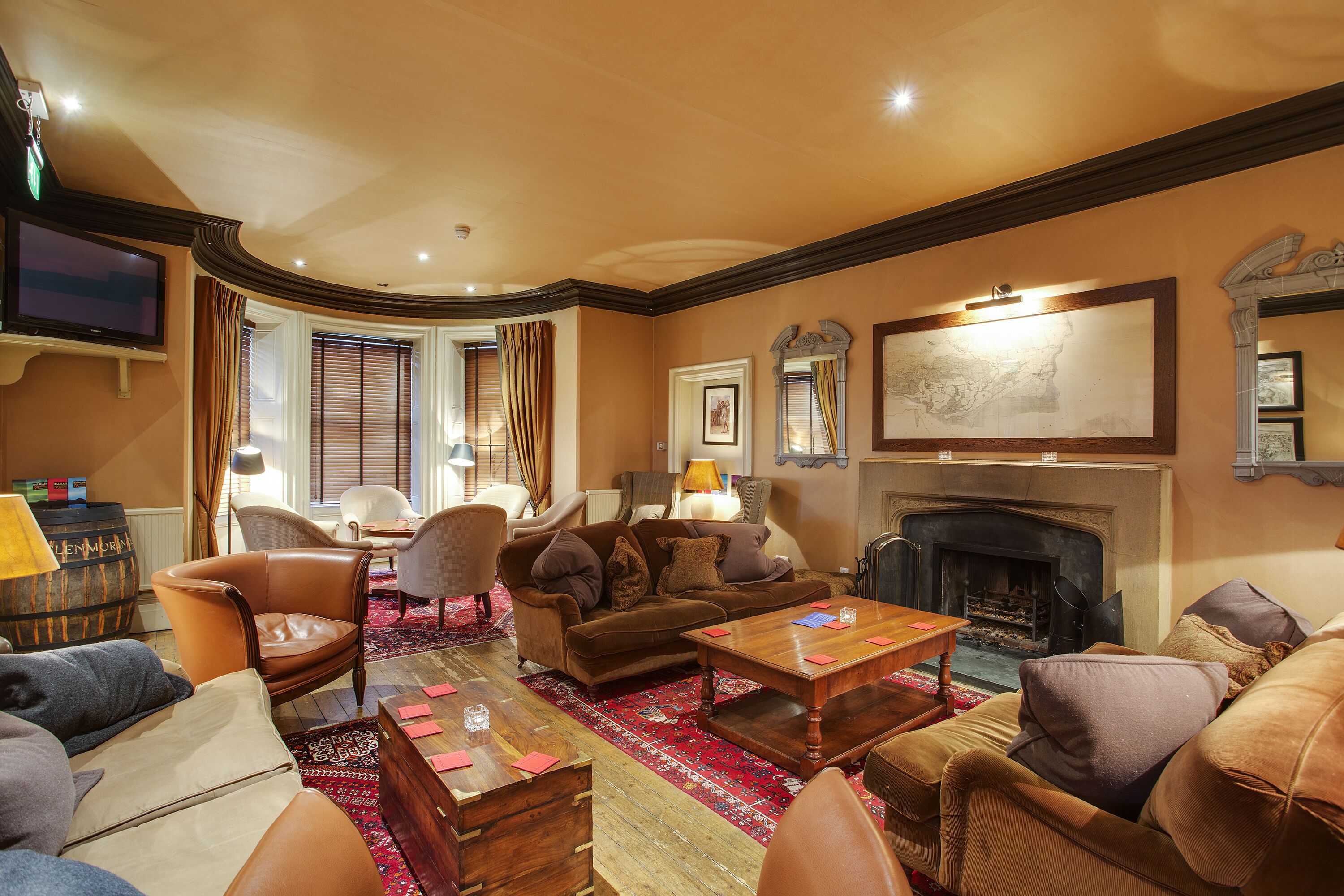 A spacious living room with a fireplace, comfortable seating, and a television.