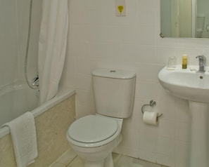 A bathroom with a toilet, a sink, and a shower. - The Ashley Hotel (Altrincham)