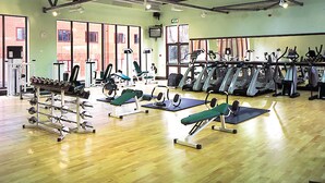 A gym with various exercise equipment, including treadmills, weight machines, and free weights. - Royal Court Hotel (Coventry)