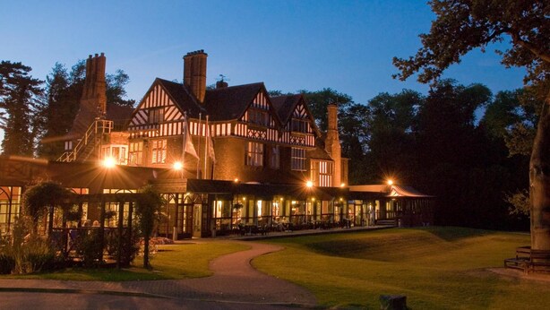 A large, historic building with multiple chimneys and a well-lit facade. - Royal Court Hotel (Coventry)
