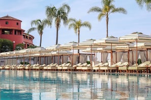 Una piscina al aire libre de temporada, camas de piscina con cargo