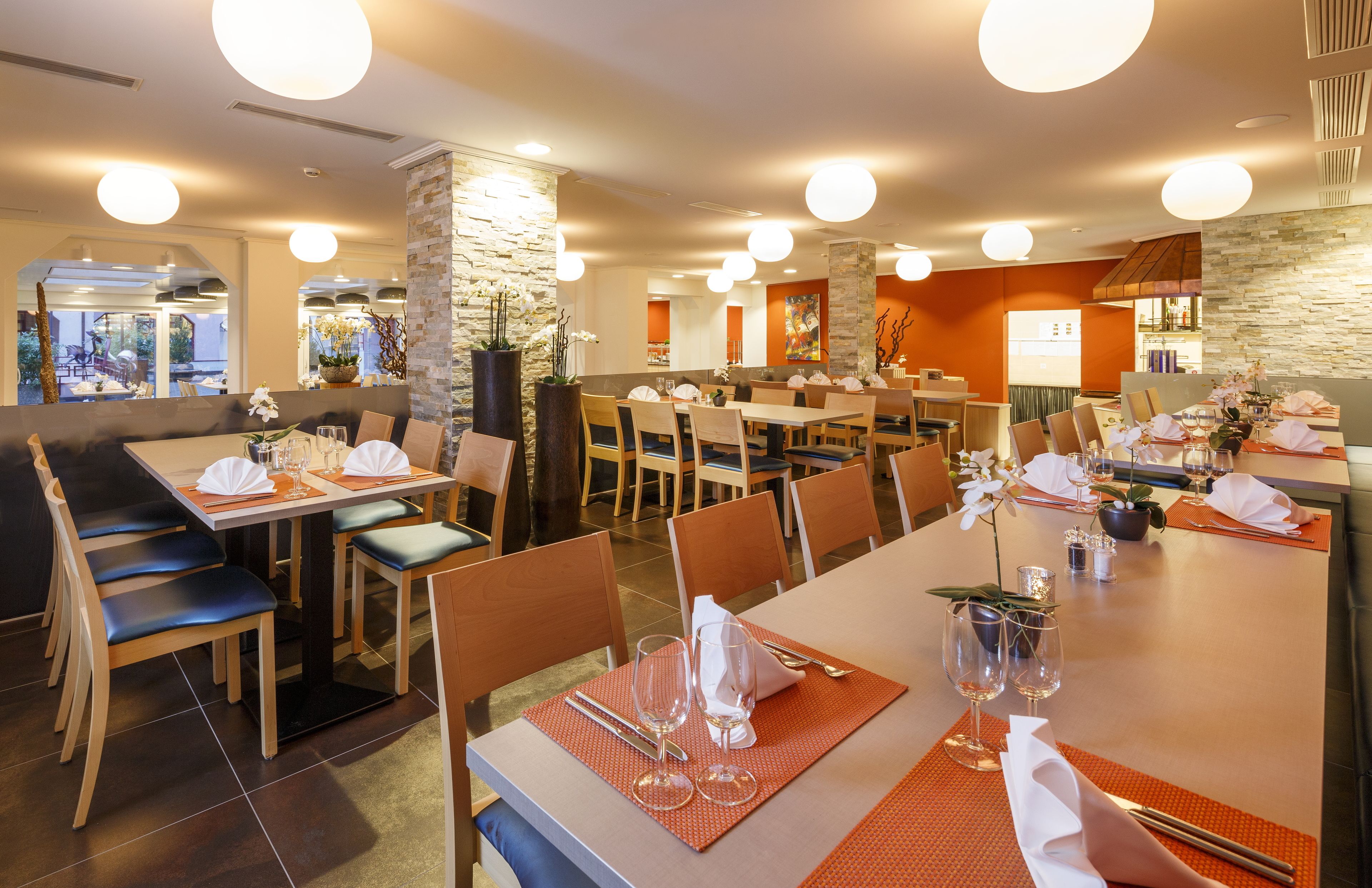 A restaurant with multiple dining areas, including booths and tables, with neatly arranged tables and chairs.