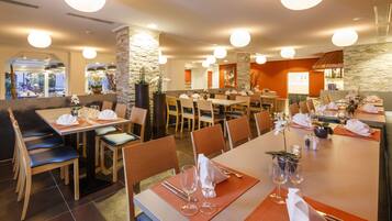 A restaurant with multiple dining areas, including booths and tables, with neatly arranged tables and chairs.
