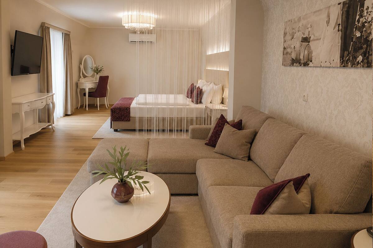 Una sala de estar moderna con un sofá modular, una mesa redonda, un televisor montado en la pared y un escritorio con una silla.